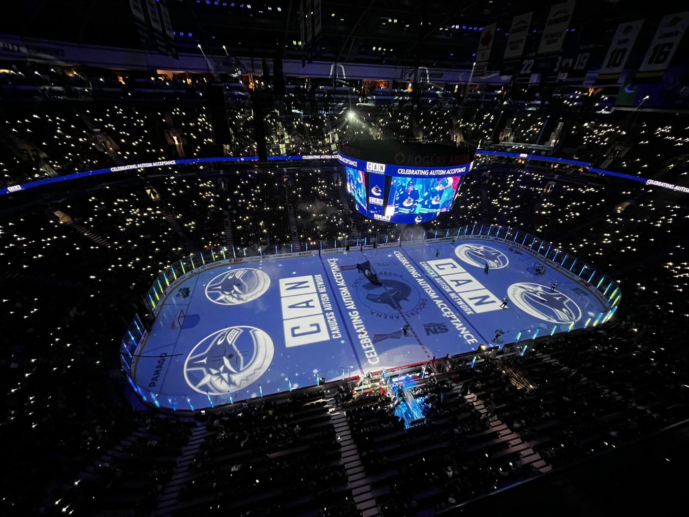 Rogers Arena lit up with the CAN logo projected on the ice