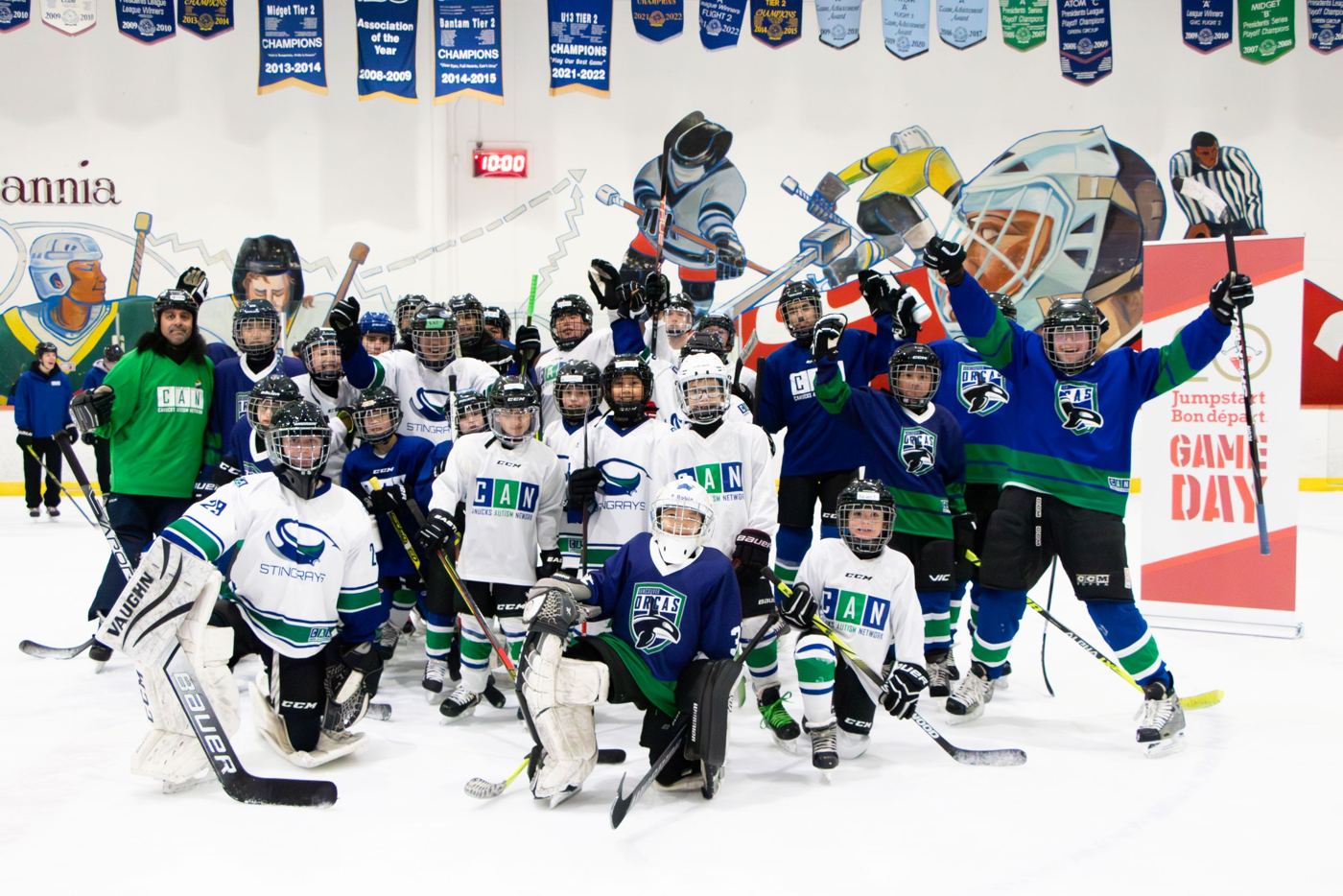 The CAN hockey group celebrating on the ice at Britannia, sticks in the air
